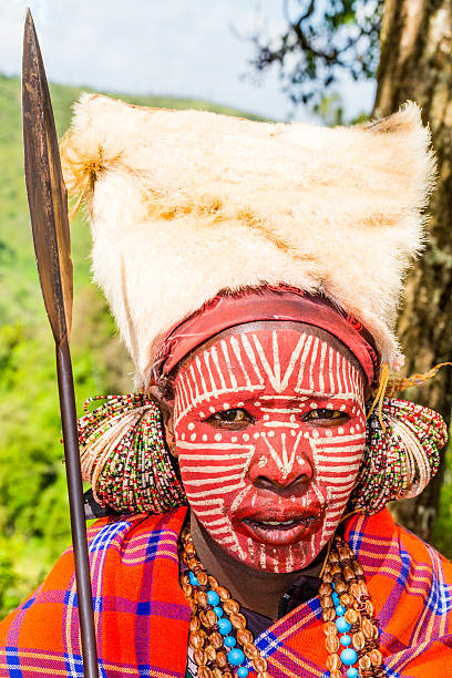 Nyahururu, Kenya - February 1, 2016 -Kikuyu female warrior wearing traditional ornaments and they are posing for money at Thomson Falls Lodge, Kenya. This people are always to be found near the falls posing for tourists and earning their money.